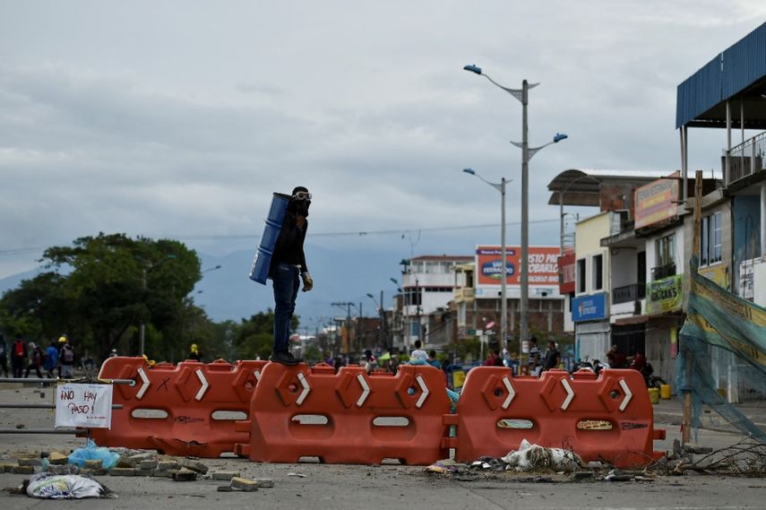 Un manifestante hace guardia en una calle bloqueada con una barricada durante una protesta contra el gobierno del presidente colombiano Iván Duque, en Cali, Colombia, el 22 de mayo de 2021.