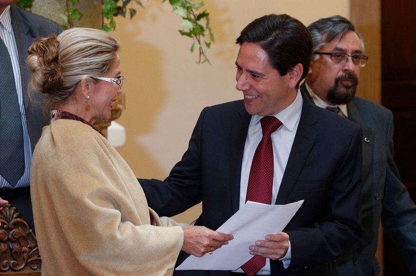 En esta fotografía de archivo del 25 de noviembre de 2019, la presidenta interina de Bolivia, Jeanine Áñez, entrega el documento a Salvador Romero que lo acredita como nuevo miembro del Tribunal Supremo Electoral durante una ceremonia en el palacio presidencial, en La Paz, Bolivia. Romero ha anunciado el miércoles 28 de abril de 2021 que renuncia a su cargo de presidente del Tribunal Supremo Electoral
