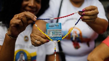 Partidarios de la oposición sostienen un rosario con un volante que muestra al candidato presidencial Edmundo González durante un evento de oración en Caracas, Venezuela, el domingo 21 de julio de 2024. Venezuela celebrará elecciones presidenciales el 28 de julio.&nbsp;