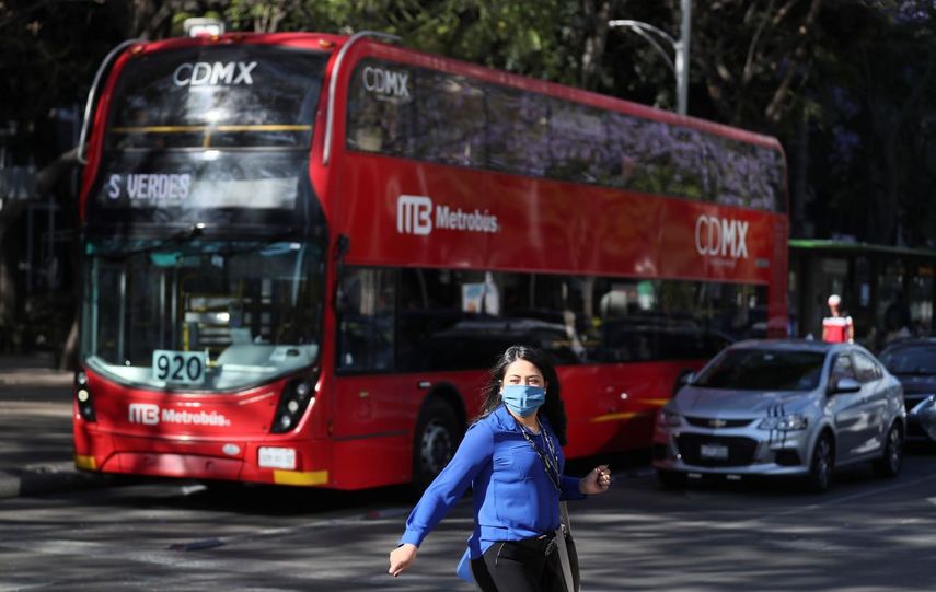 Una mujer usa una m&aacute;scara protectora como precauci&oacute;n contra la propagaci&oacute;n del nuevo coronavirus mientras cruza el Paseo de la Reforma en la Ciudad de M&eacute;xico, el lunes 23 de marzo de 2020.