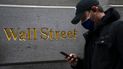 Un hombre pasa frente al letrero de Wall Street en su sede en Nueva York.