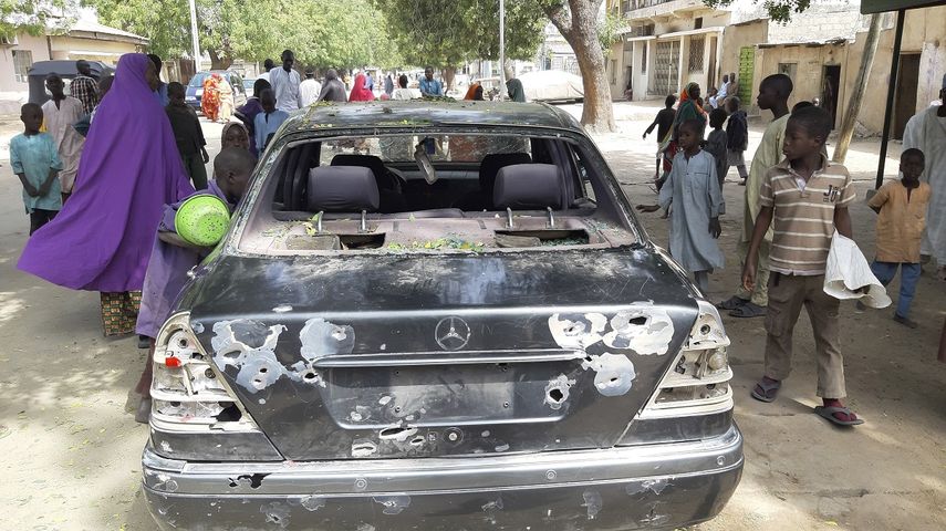 Personas observan un vehículo acribillado a tiros en el lugar de un ataque en la ciudad de Maiduguri, Nigeria, el miércoles 24 de febrero de 20021. Las autoridades dijeron que al menos 10 personas murieron y 60 resultaron heridas en el ataque.&nbsp;