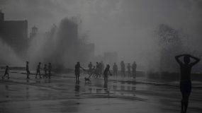 La gente juega en las olas que rompen en el Malecón, después del huracán Ian en La Habana, Cuba, el miércoles 28 de septiembre de 2022. 