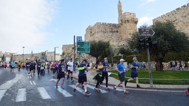 Corredores transitan a lo largo de la muralla de la Vieja Ciudad de Jerusalén.
