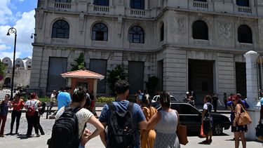 Los trabajadores revisan sus teléfonos celulares después de un temblor causado por un terremoto de magnitud 6,5 en La Habana, el 8 de junio de 2026.