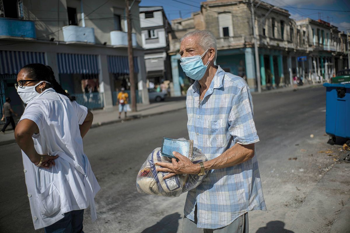 Un cubano lleva entre sus manos una ración mensual de alimentos básicos subsidiados por el régimen. Un cubano lleva entre sus manos una ración mensual de alimentos básicos subsidiados por el régimen.