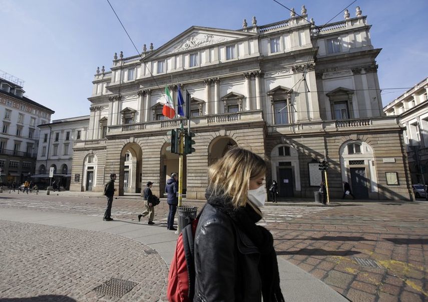 En esta fotograf&iacute;a del 24 de febrero de 2020 una mujer con una m&aacute;scara sanitaria pasa frente a la &oacute;pera La Scala en Mil&aacute;n, Italia.&nbsp;&nbsp;