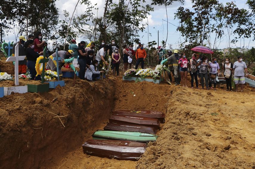 En esta imagen, tomada el 21 de abril de 2020, familiares asisten a un entierro m&uacute;ltiple en el cementerio Nossa Senhora Aparecida, en Manaos, en el estado de Amazonas, Brasil. El cementerio realiza entierros en fosas comunes ante el elevado n&uacute;mero de decesos por el COVID-19, dijo un funcionario.