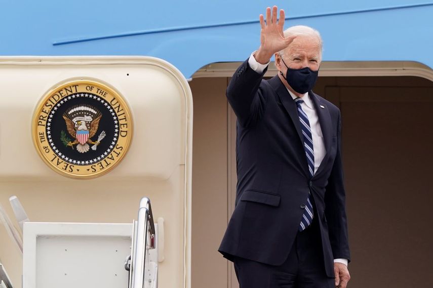 El presidente Joe Biden saluda en lo alto de la escalinata del avión presidencial Air Force One.