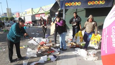 Una turba heterogénea y amorfa terminaba de extraer de los locales comerciales los pocos productos que todavía quedaban ante la desazón de los ciudadanos que salían la calle a cumplir con su jornada laboral.