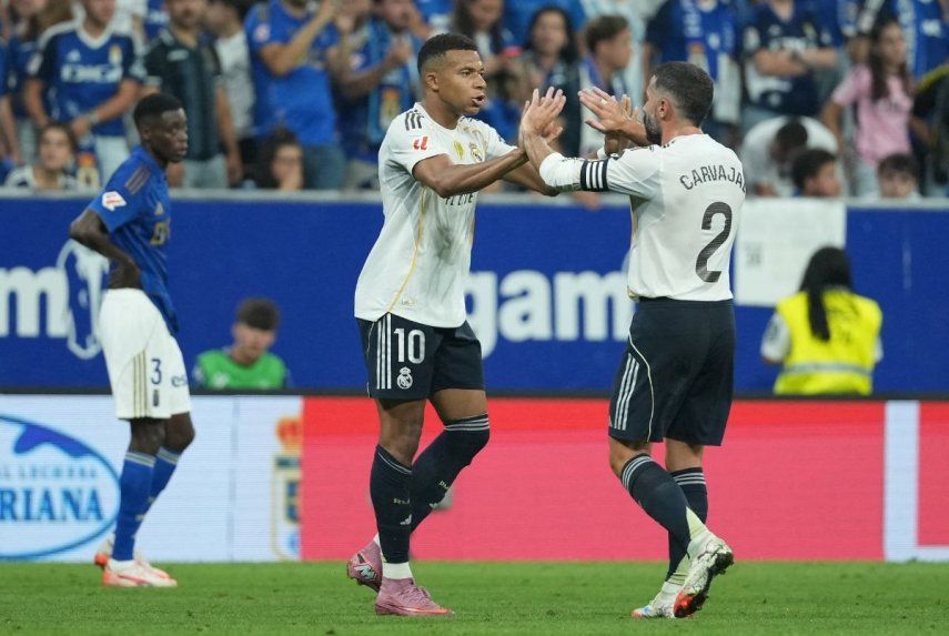 El delantero francés del Real Madrid, el número 10, Kylian Mbappé, celebra el primer gol de su equipo con el defensa español del Real Madrid, el número 2 Dani Carvajal, durante el partido de fútbol de la liga española entre el Real Oviedo y el Real Madrid CF en el estadio Carlos Tartiere de Oviedo, el 24 de agosto de 2025.