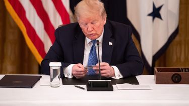 El presidente Donald Trump&nbsp;mira una tarjeta de d&eacute;bito usada para la distribuci&oacute;n de ayuda por el&nbsp;COVID-19,&nbsp;en la Casa Blanca,&nbsp;Washington, DC, el 19 de mayo de 2020.&nbsp;