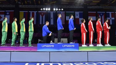E estadounidense Race Imboden, del equipo de esgrima, se arrodilla en señal de protesta durante la ceremonia en que él y sus compañeros recibieron la medalla de oro en florete por equipos en los Juegos Panamericanos de Lima 2019.&nbsp;