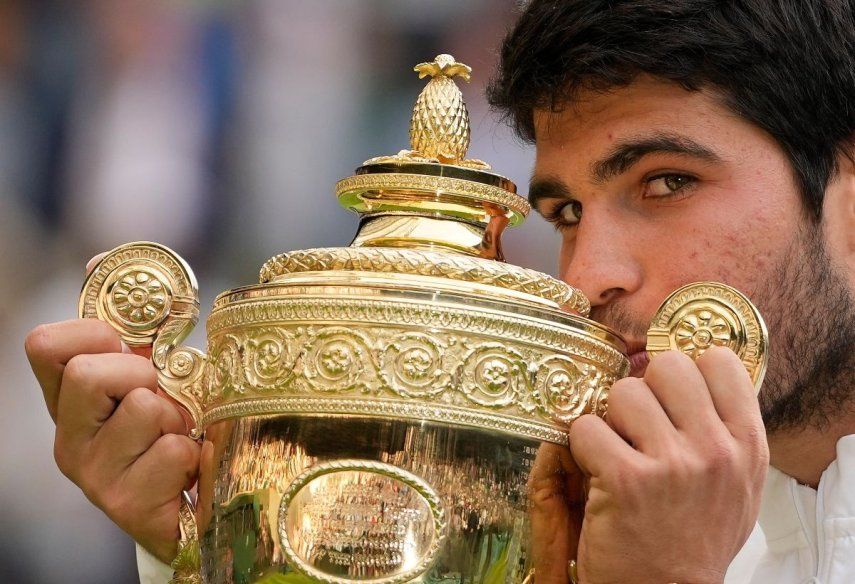 En foto del 16 de julio del 2024, el español Carlos Alcaraz celebra con el trofeo al vencer a Novak Djokovic en la final de Wimbledon.