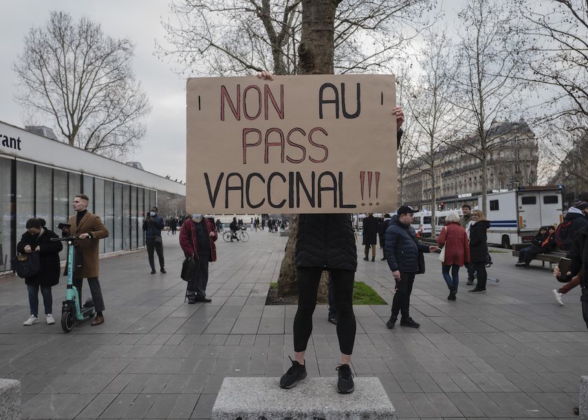 Una persona sostiene un cartel con el mensaje ¡No al pase de vacunas! en una protesta contra el pase de vacunas contra el COVID-19, en París, Francia, el sábado 22 de enero de 2022.&nbsp;