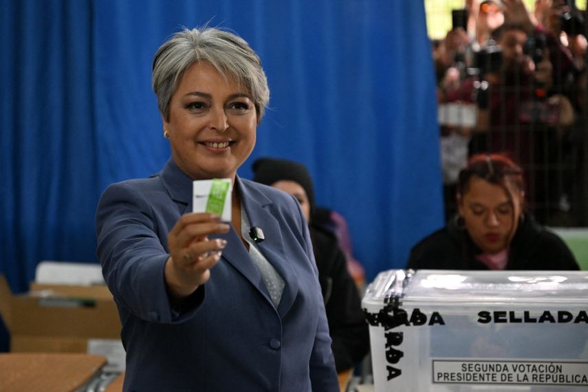 La candidata presidencial  Jeannette Jara, de la coalición Unidad por Chile, muestra su papeleta antes de emitir su voto durante la segunda vuelta de las elecciones presidenciales en Santiago el 14 de diciembre de 2025.