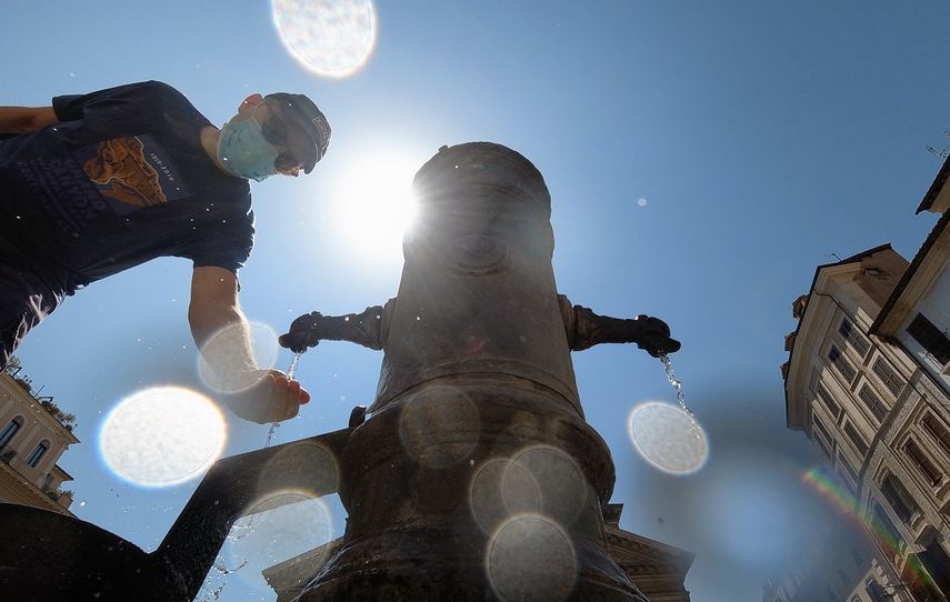 Un turista que lleva una mascarilla se refresca en una fuente Nasone en el centro de Roma el 12 de agosto de 2020.&nbsp;