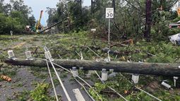 Cuadrillas de trabajadores retiran postes quebrados y cableado eléctrico derribado por los fuertes vientos, en una calle de Tallahassee, Florida, el viernes 10 de mayo de 2024