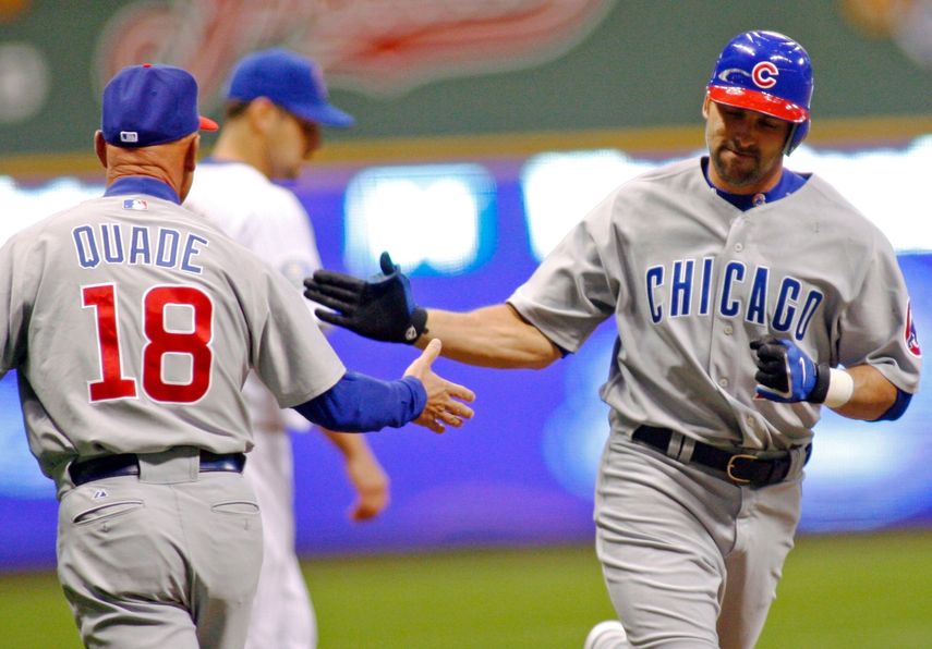 &nbsp;- Mark DeRosa, derecha, de los Cachorros de Chicago, es felicitado por el coach de tercera base Mike Quade, izquierda, tras pegar un jonrón frente a los Cerveceros de Milwaukee, el viernes 6 de abril de 2007, en Milwaukee.&nbsp;