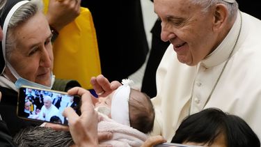 El papa Francisco saluda a un recién nacido al cabo de su audiencia general semanal en la sala Pablo VI, Vaticano, 1 de diciembre de 2021. 