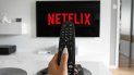 Una persona con un control de televisión entra en la plataforma de Netflix. Una persona con un control de televisión entra en la plataforma de Netflix.