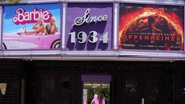 Una persona compra boletos de cine debajo de una marquesina con las películas Barbie y Oppenheimer&nbsp;en el cine Los Feliz, el viernes 28 de julio de 2023 en Los Ángeles.&nbsp;