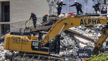 Personal especializado busca a sobrevivientes entre los restos del edificio de apartamentos Champlain Towers, de 12 niveles, que el jueves se vino abajo parcialmente, en la localidad de Surfside, en Florida