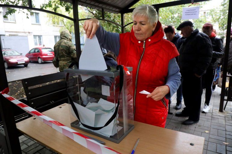Una mujer deposita su voto durante un referéndum en un colegio electoral móvil en Mariúpol, en la región ucraniana de Donetsk, controlada por separatistas respaldados por Rusia, el viernes 23 de septiembre de 2022. 