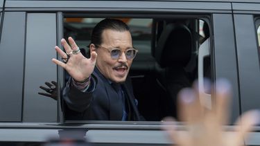 El actor Johnny Depp saluda a sus seguidores al salir del Tribunal del Condado de Fairfax el viernes 27 de mayo de 2022 en Fairfax, Virginia.