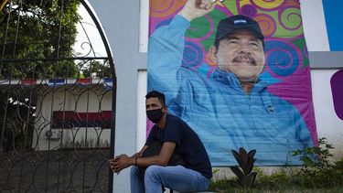 Un hombre se sienta frente a una pancarta que promueve la candidatura del presidente de Nicaragua, Daniel Ortega, en Managua el 24 de septiembre de 2021. Nicaragua inicia oficialmente la campaña para las elecciones presidenciales del 7 de noviembre el sábado, con los principales rivales del presidente Daniel Ortega arrestados y el camino libre para él. buscar un cuarto mandato consecutivo en el cargo.    