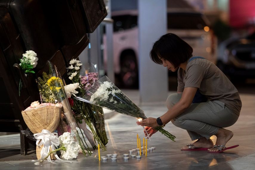 Una mujer enciende una vela en el centro comercial Terminal 21 Korat, en Tailandia, después de una balacera que dejó al menos 29 muertos, el domingo 9 de febrero de 2020.