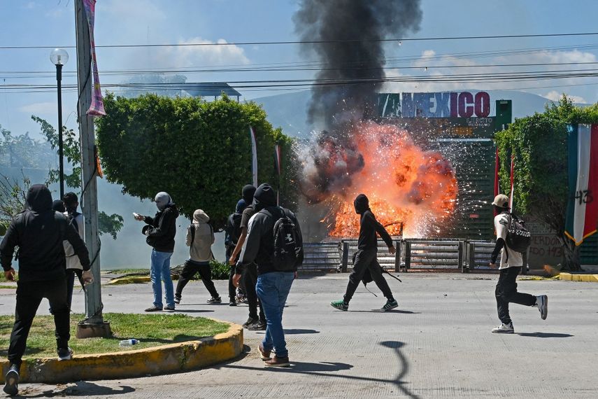 La gente lanza fuegos artificiales al cuartel de la zona militar 35-C durante una manifestación por el 11º aniversario de la desaparición de 43 estudiantes de Ayotzinapa, en Iguala, estado de Guerrero, México, el 23 de septiembre de 2025.