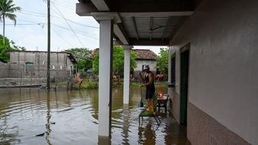 Un hombre se encuentra afuera de una casa inundada en la comunidad El Cubulero, municipio de La Alianza, departamento de Valle, Honduras, el 21 de junio de 2024, luego del desbordamiento del río Goascorán debido a las fuertes lluvias. Las lluvias torrenciales en Centroamérica han dejado al menos 27 muertos en deslizamientos de tierra e inundaciones durante la semana pasada, principalmente en El Salvador, pero también en Guatemala y Honduras, dijeron funcionarios el viernes.