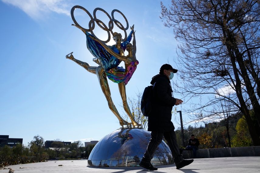 Un visitante pasa junto a una escultura por los Juegos Olímpicos de Invierno de Beijing, en el parque Shougang, en Beijing, China