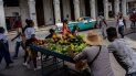 Dos vendedores ambulantes empujan su carrito con frutas y verduras el jueves 4 de agosto de 2022, en La Habana, Cuba. 
