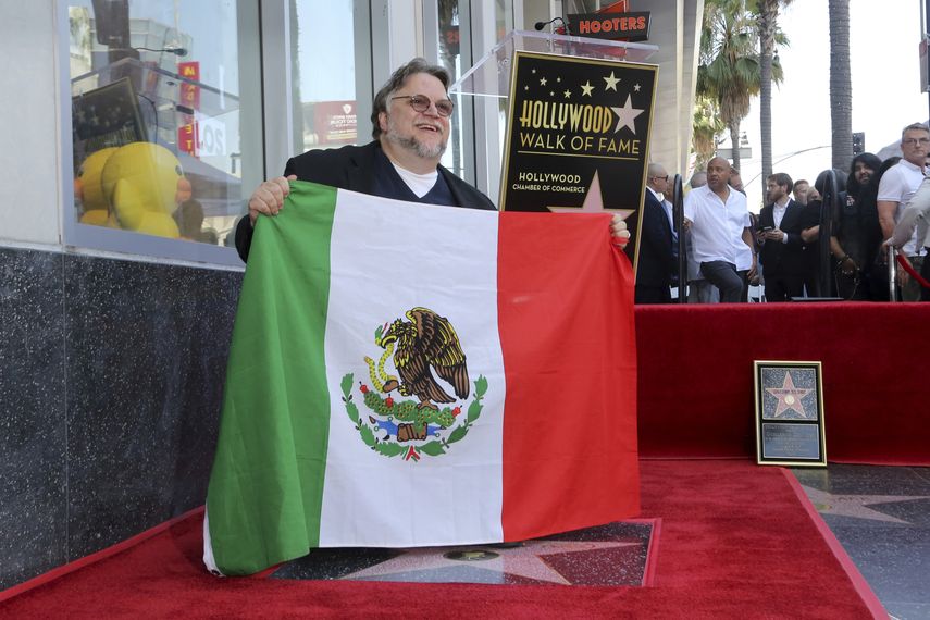 Guillermo del Toro posa con la bandera de México  tras una ceremonia en su honor para develar su estrella en el Paseo de  la Fama de Hollywood el martes 6 de agosto de 2019 en Los Angeles.&nbsp;