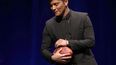 Bruno Mars, quien encabezará el espectáculo de medio tiempo en el Super Bowl XLVIII de la NFL, toma el balón del partido durante una conferencia de prensa. (AP)
