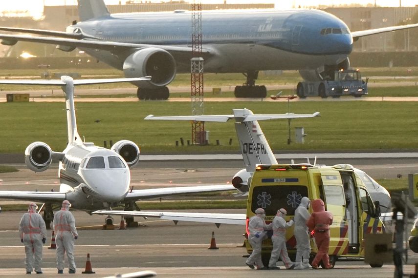 Una persona con un traje de protección contra materiales peligrosos (2R) es escoltada a una ambulancia desde un avión medicalizado que supuestamente transportaba a algunos de los pasajeros del crucero MV Hondius, presuntamente infectado con hantavirus, en el aeropuerto de Schiphol, cerca de Ámsterdam, el 6 de mayo de 2026. &nbsp;