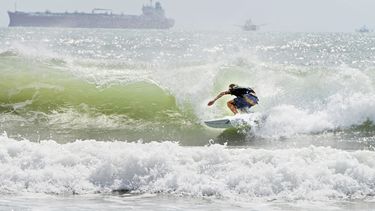 Un surfista se desplaza a orillas de la isla del Padre Sur el viernes 24 de julio de 2020 en medio de un mar picado debido a la tormenta tropical Hanna.&nbsp;
