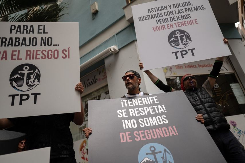 Los estibadores portan pancartas con el lema Trabajadores del puerto de Tenerife - TPT (Trabajadores del Puerto de Tenerife) - Respeten Tenerife - no somos de segunda clase en protesta por la llegada de un crucero afectado por el hantavirus a Santa Cruz de Tenerife el 8 de mayo de 2026.