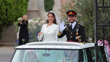 El príncipe heredero de Jordania, Hussein bin Abdalá, y su esposa, la saudita Rajwa al-Seif, saludan al salir del Palacio de Zahran en Amán el 1 de junio de 2023 después de la ceremonia de su boda real.&nbsp; &nbsp;