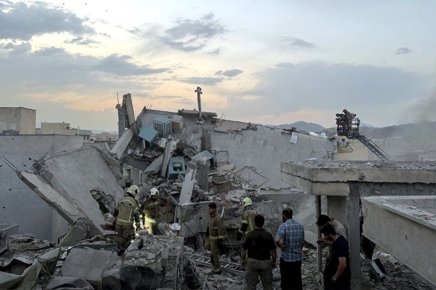 Personas y personal de emergencia se congregan en la azotea de un edificio que fue alcanzado por un ataque israelí en Teherán el 13 de junio de 2025. 
