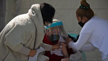 Una mujer recibe su primera dosis de la vacuna AstraZeneca contra COVID-19 en la Ciudad de México, el 15 de febrero de 2021, cuando México comienza a vacunar a personas mayores de 60 años. México inició este lunes la segunda fase de su plan de vacunación masiva contra COVID-19 con personas mayores de 60 años. La primera fase, que se centró en el personal médico, duró casi un mes debido a retrasos en la entrega de las dosis.