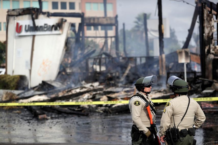 &nbsp; Polic&iacute;as del condado San Diego montan guardia el domingo 31 de mayo de 2020 frente a una sucursal bancaria quemada en La Mesa, California, despu&eacute;s de una violenta protesta por la muerte de George Floyd en Minneapolis. &nbsp;