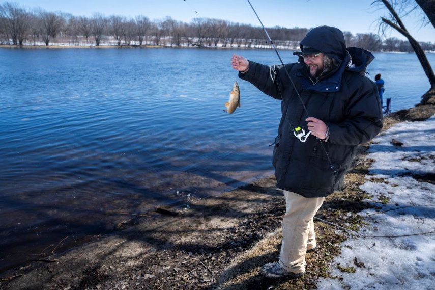 Tyler Abayare pesca una carpa en el Mississippi río abajo de la planta nuclear Xcel Energy en Monticello, Minnesota, 24 de marzo de 2023.&nbsp;