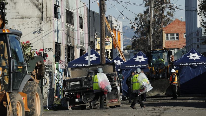 Policías y bomberos continúan las labores de inspección y rescate de posibles víctimas del incendio de este viernes durante un concierto de música electrónica en Oakland, California.