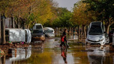 Personas cruzan la calle después de las inundaciones en Utiel, España, el miércoles 30 de octubre del 2024.