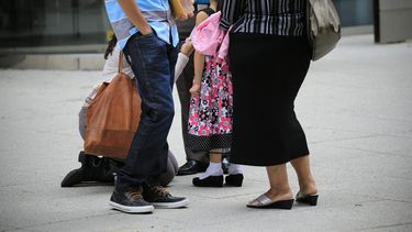 Una familia de inmigrantes aguarda por la decisión del juez, en las afueras de un tribunal de Inmigración.