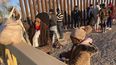Una mujer cubana y su hija esperan en fila para ser llevadas a una furgoneta de la Patrulla Fronteriza de Estados Unidos oara su procesamiento en Yuma, Arizona, el 6 de febrero del 2022.&nbsp;