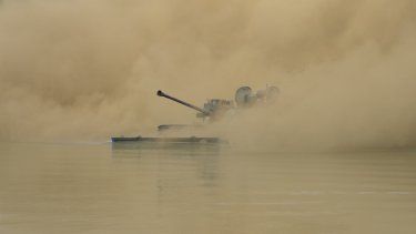 Un vehículo de combate K21 de la infantería de Corea del Sur navega hasta la orilla en medio del humo durante una maniobras conjuntas con el ejército de Estados Unidos, en Cheorwon, Corea del Sur, el 31 de agosto de 2023.